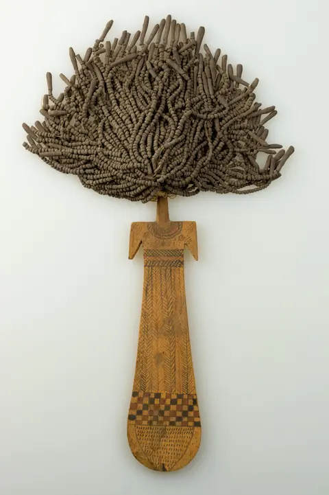 An ancient Egyptian wooden paddle doll painted with geometric patterns and strung clay beads for hair