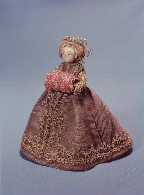 An antique 'Pandora' fashion doll on a wire frame, wearing a violet silk gown