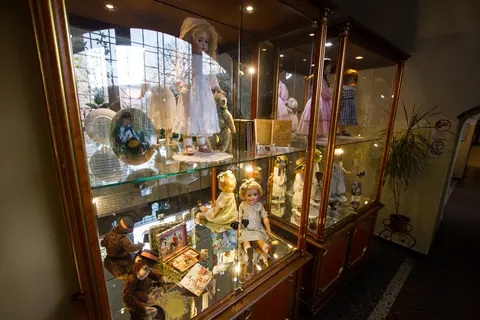Visitors viewing a wide display of antique dolls at a doll collectors' exhibition