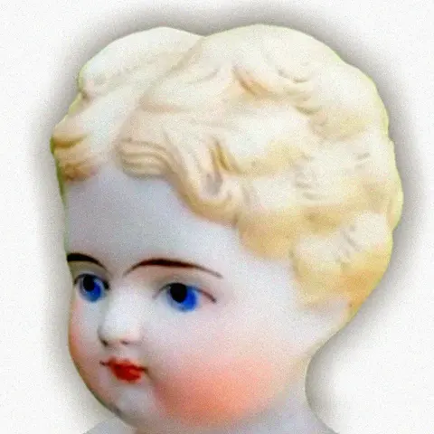 An antique Parian doll with pale untinted porcelain skin and molded blonde hair, head and shoulders