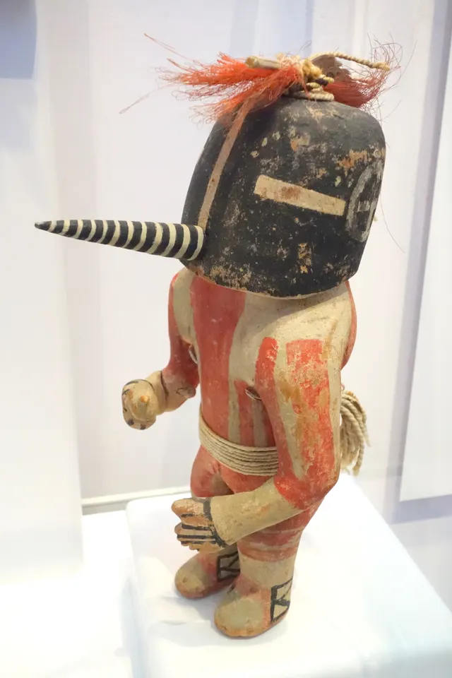 A Kokopelli Hopi katsina doll, carved wood with pigment, cotton, feathers and horsehair, late 19th century